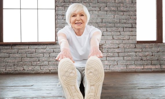 angebenÄltere Frau macht eine Dehnübung.